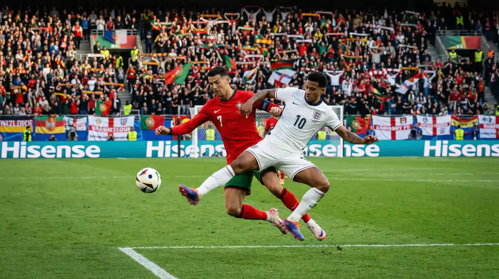 Imreoirí idirnáisiúnta sacair ag dul i ngleic ar pháirc glas le lucht féachana i staidiam